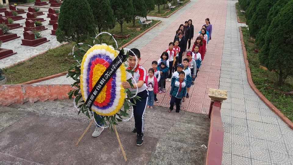 Các em thầy cô cùng các em học sinh dâng hoa tai Đài tưởng niệm.