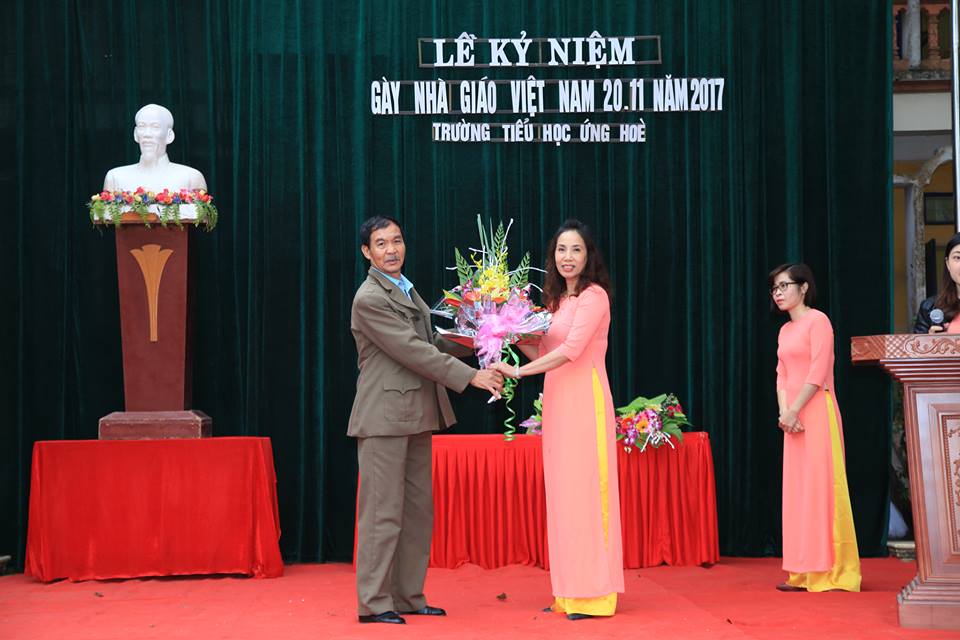 Ông Nguyễn Công Chính - CT Hội cựu giáo chức tặng hoa chúc mừng.